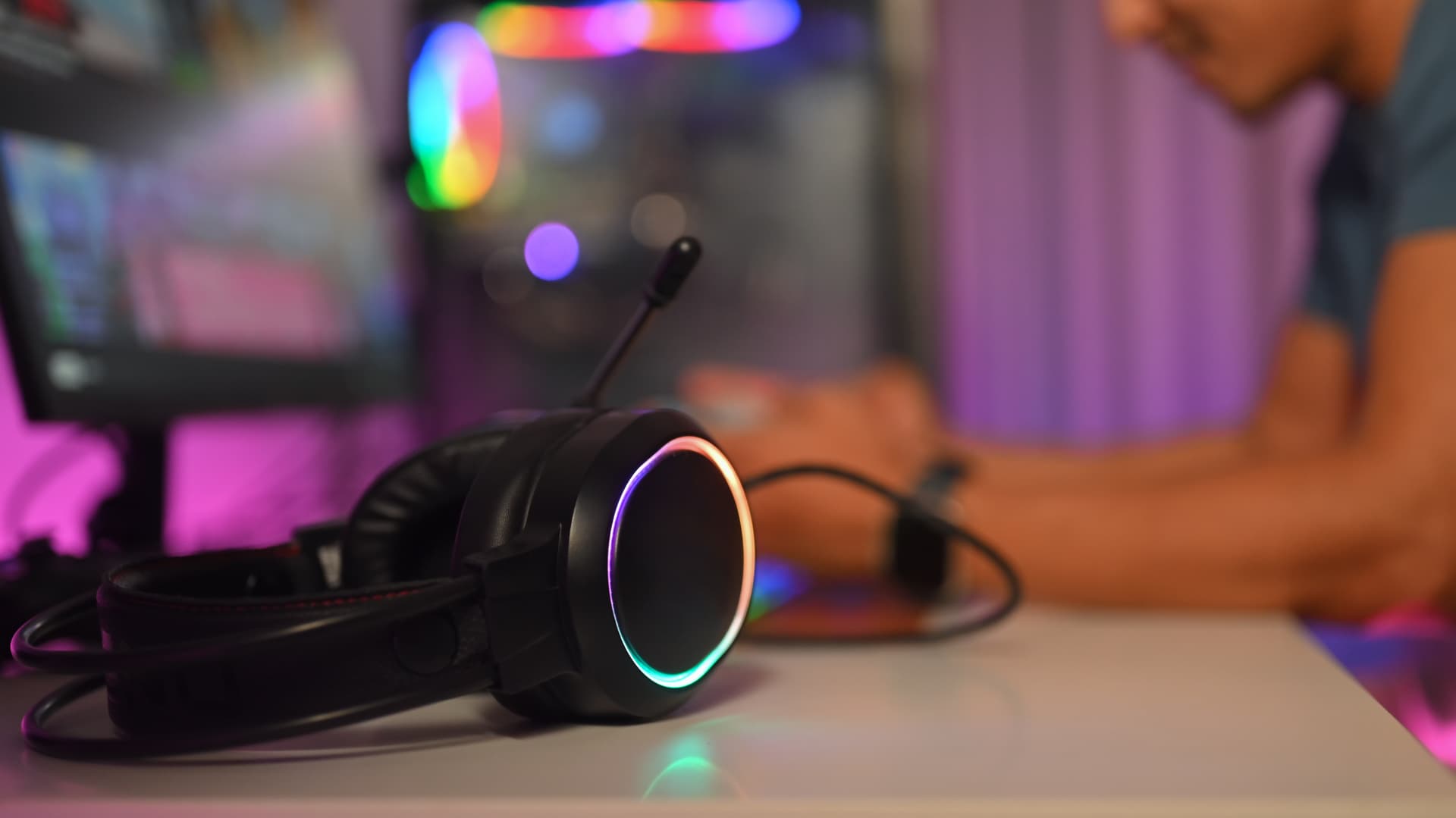 close-up-of-headset-on-desk-with-male-gamer-sittin-2024-12-04-15-05-08-utc.jpg